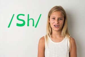 A girl learning to pronounce the sound sh