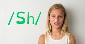 A girl learning to pronounce the sound sh